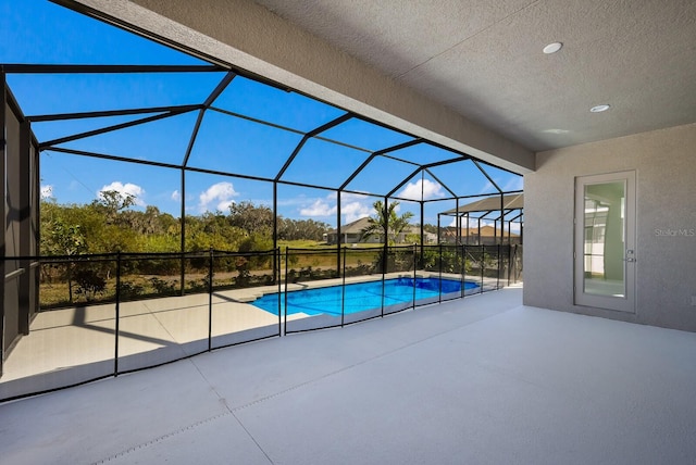 view of pool with a patio area and a lanai