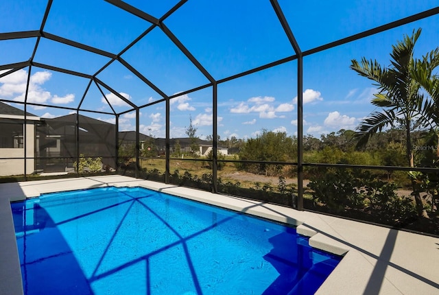 view of swimming pool featuring a patio and glass enclosure