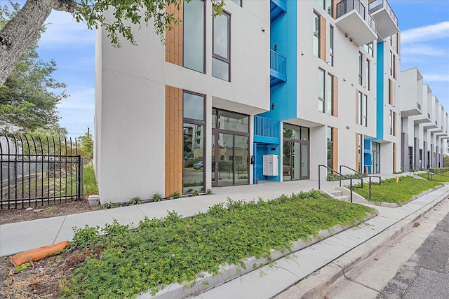 view of building exterior with a residential view and fence