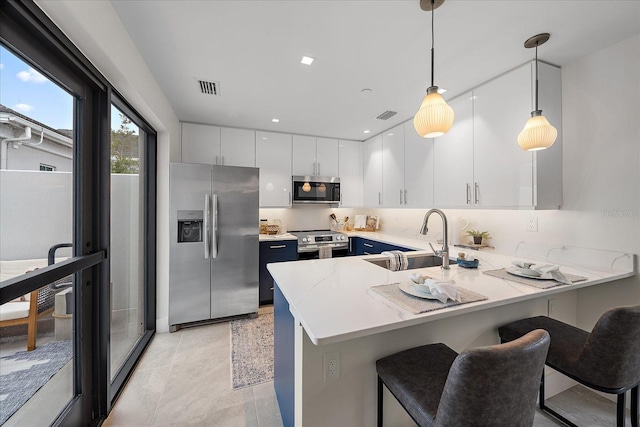 kitchen with hanging light fixtures, kitchen peninsula, sink, and stainless steel appliances