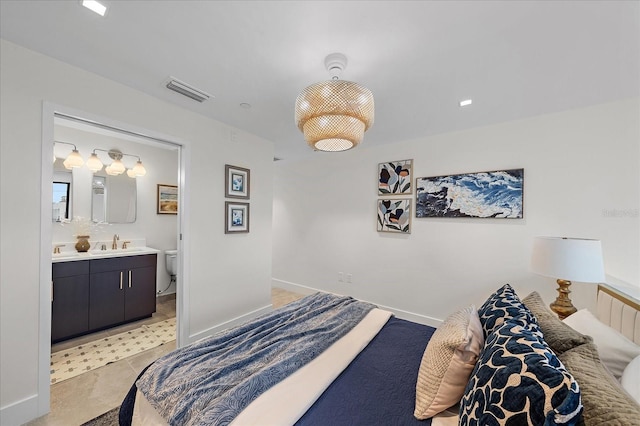 bedroom featuring light tile patterned floors, ensuite bathroom, and sink