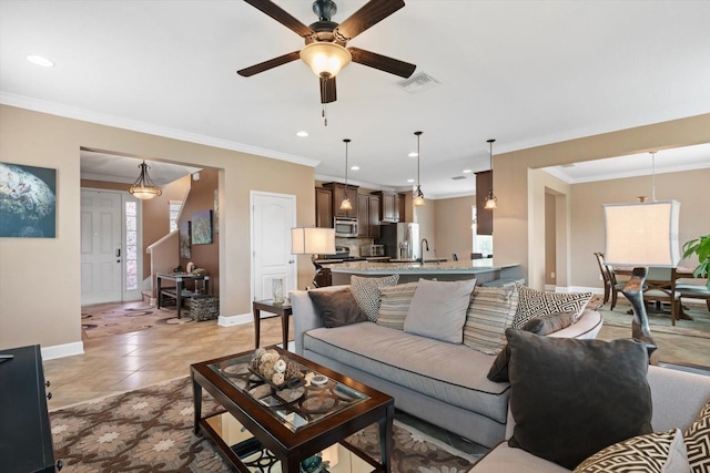 living room with crown molding, ceiling fan, sink, and light tile patterned floors