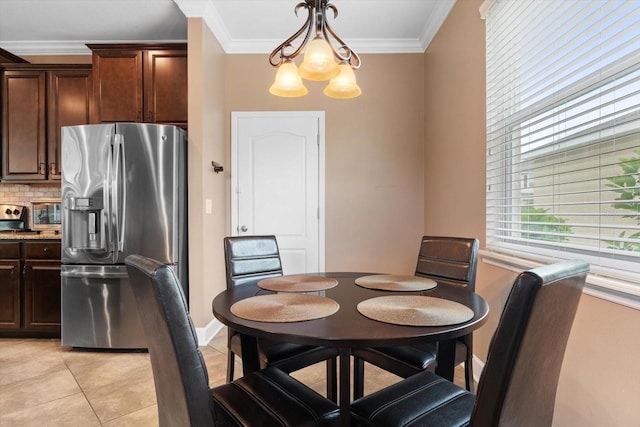 dining room featuring a notable chandelier, ornamental molding, and light tile patterned flooring