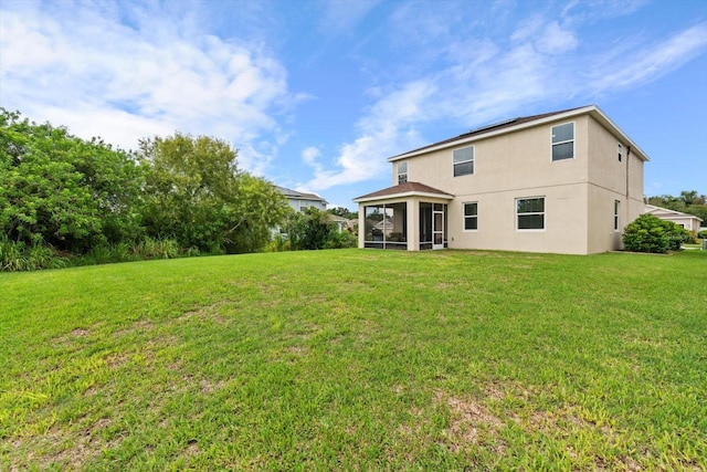 rear view of property featuring a lawn and a sunroom