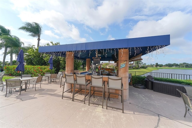 view of patio / terrace with a water view and exterior bar