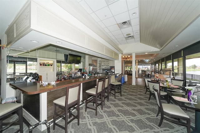 bar with dark colored carpet and green cabinets