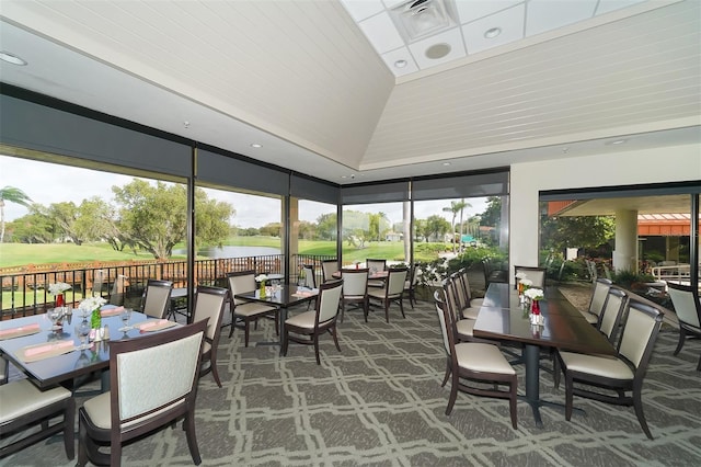 sunroom featuring vaulted ceiling, a healthy amount of sunlight, and a water view