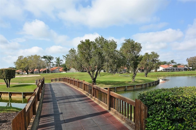 view of property's community with a yard and a water view