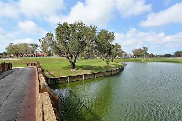 dock area featuring a water view and a lawn