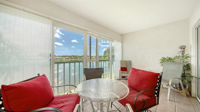 sunroom featuring a water view