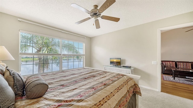 bedroom featuring a textured ceiling, carpet flooring, and ceiling fan