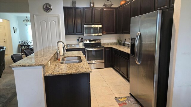 kitchen featuring a breakfast bar, stainless steel appliances, light stone countertops, light colored carpet, and sink