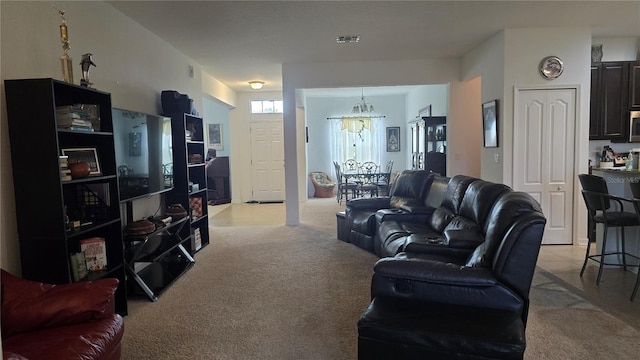 carpeted living room with an inviting chandelier