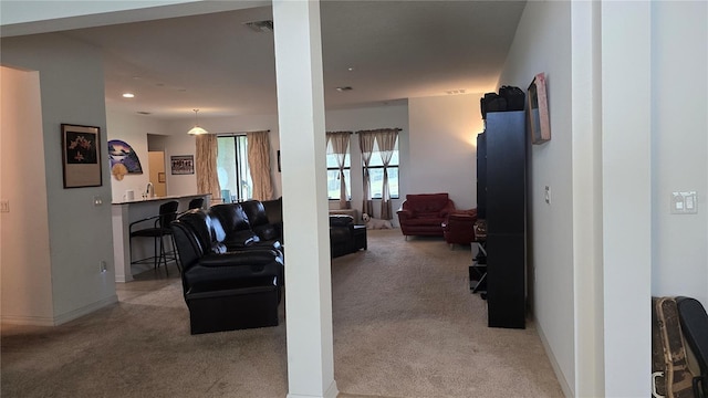 living area featuring recessed lighting, baseboards, visible vents, and light colored carpet