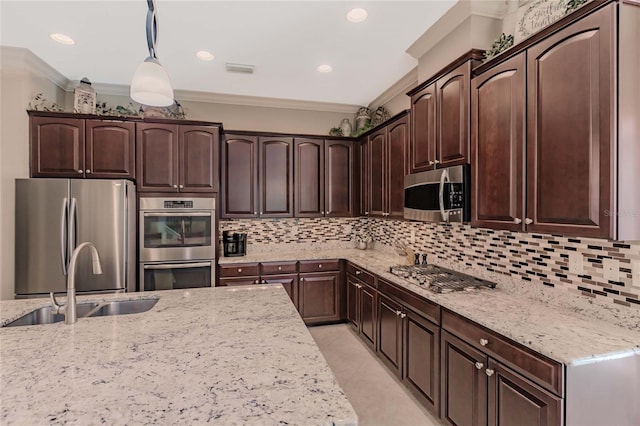 kitchen featuring appliances with stainless steel finishes, dark brown cabinetry, crown molding, sink, and hanging light fixtures