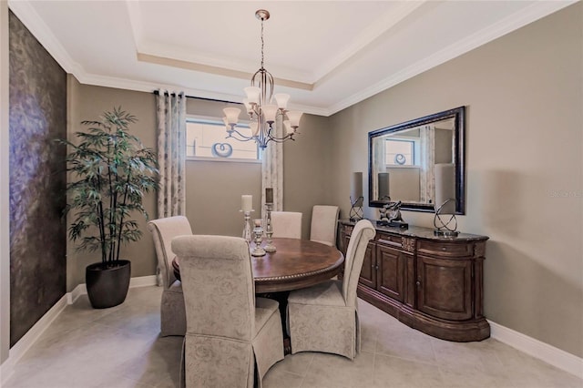 dining space with a tray ceiling, a wealth of natural light, and a chandelier