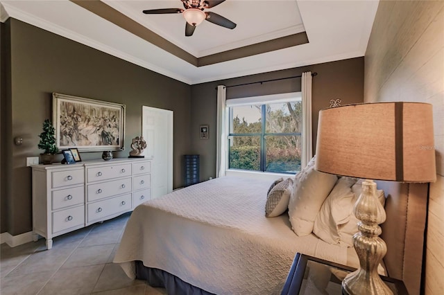 bedroom with tile patterned flooring, a tray ceiling, and ceiling fan