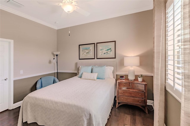 bedroom featuring ceiling fan, dark hardwood / wood-style flooring, ornamental molding, and multiple windows