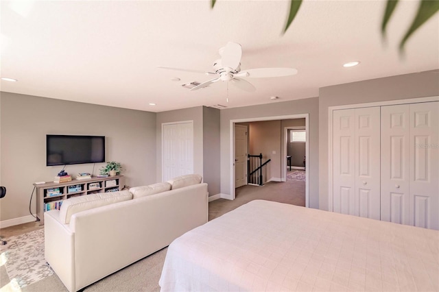 bedroom featuring ceiling fan, carpet, and two closets