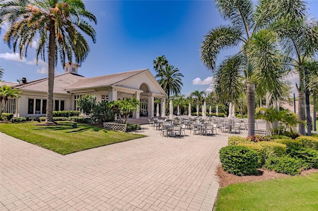 view of home's community featuring a lawn and a patio area