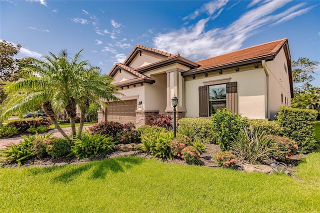 mediterranean / spanish home featuring a front yard and a garage