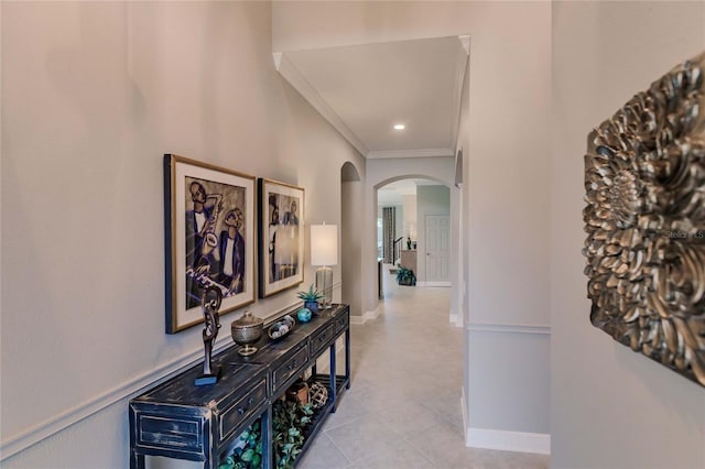 hall featuring light tile patterned flooring and crown molding