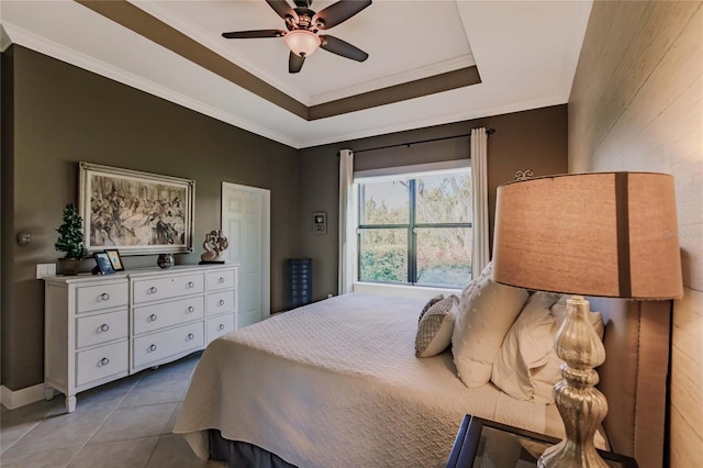 tiled bedroom with a tray ceiling and ceiling fan