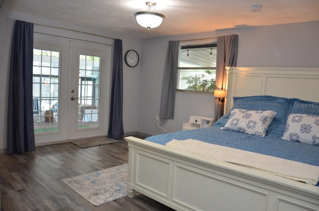 bedroom with access to exterior, dark wood-type flooring, french doors, and a textured ceiling