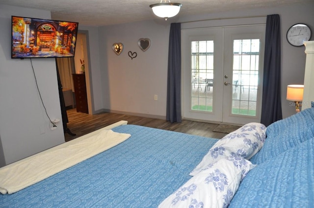 bedroom featuring french doors, hardwood / wood-style floors, and a textured ceiling