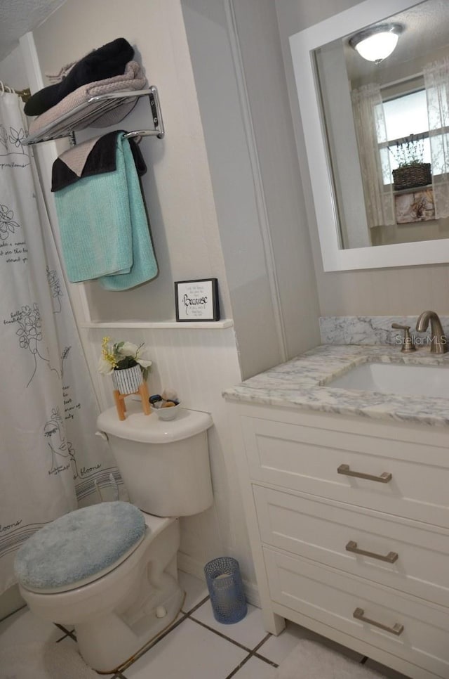 bathroom with vanity, tile patterned floors, and toilet