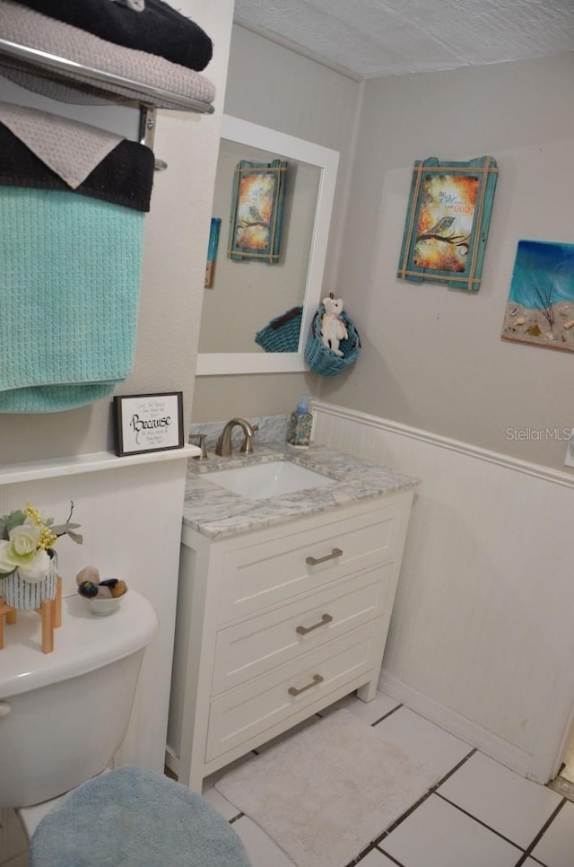 bathroom with tile patterned flooring, toilet, and vanity