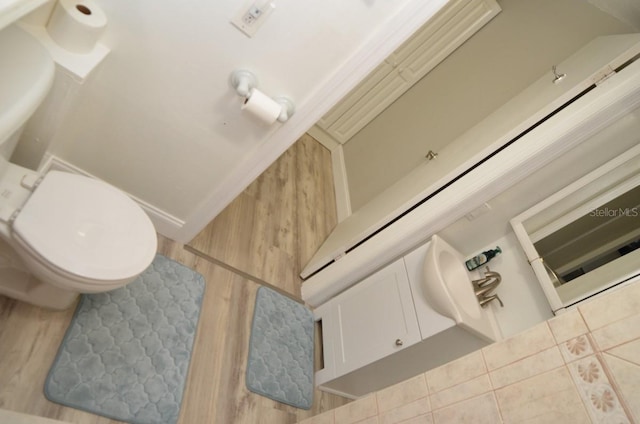 bathroom with a baseboard radiator, tile patterned floors, and toilet