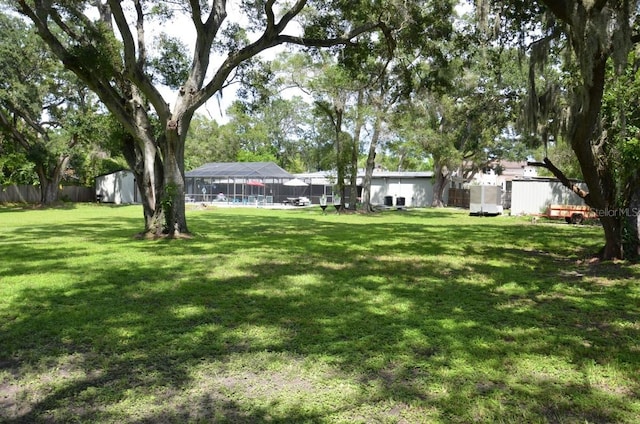 view of yard with a storage shed and glass enclosure