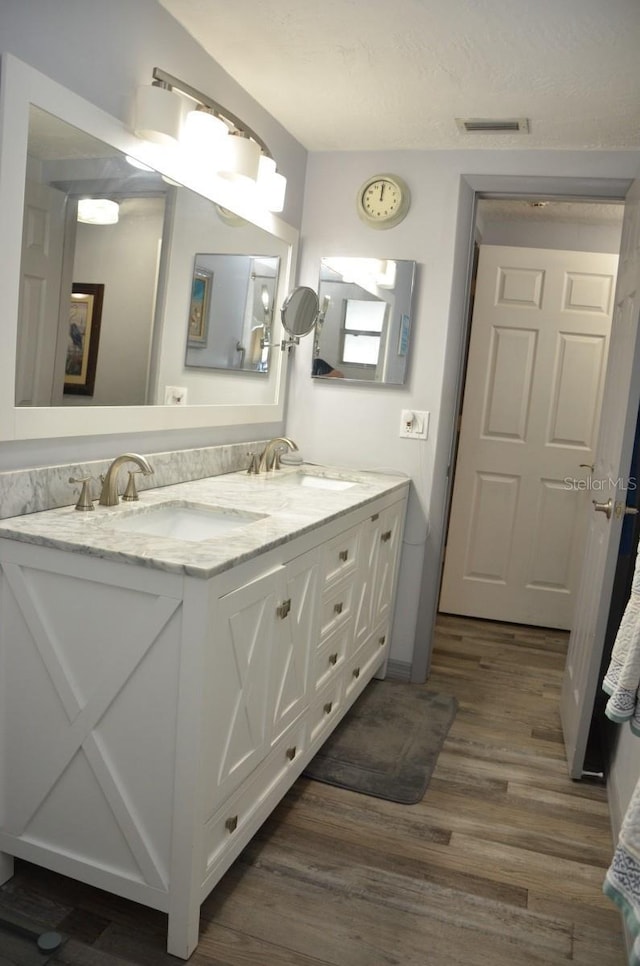 bathroom featuring hardwood / wood-style flooring and dual bowl vanity