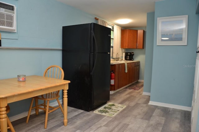 kitchen featuring light hardwood / wood-style floors, sink, and black refrigerator