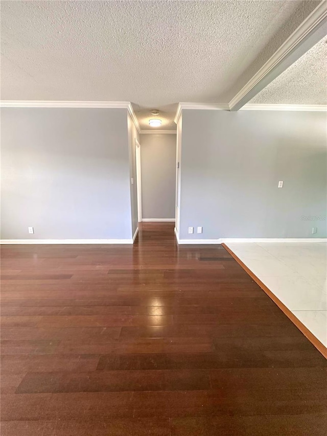 unfurnished room featuring a textured ceiling, ornamental molding, and hardwood / wood-style floors