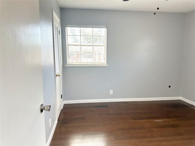 spare room with dark hardwood / wood-style flooring