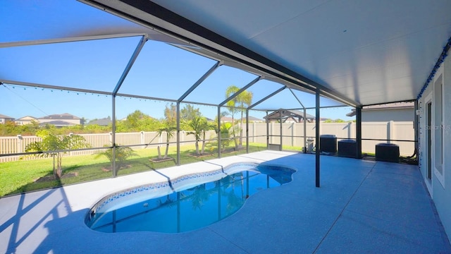 view of swimming pool featuring central AC unit, glass enclosure, a patio area, and a yard