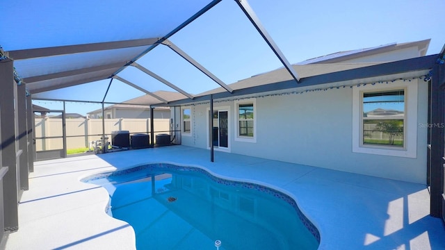 view of pool featuring glass enclosure and a patio