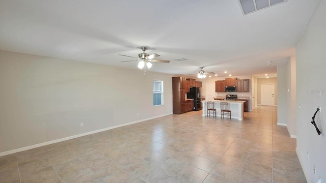 unfurnished living room with ceiling fan and light tile patterned floors