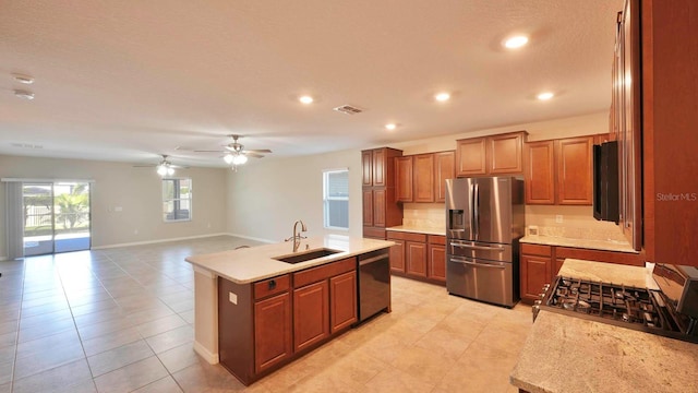 kitchen with sink, ceiling fan, an island with sink, light tile patterned flooring, and stainless steel appliances