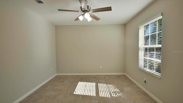 tiled spare room featuring a wealth of natural light and ceiling fan