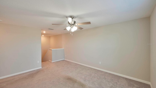 carpeted spare room featuring ceiling fan