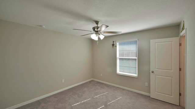 empty room with a textured ceiling, ceiling fan, and light carpet