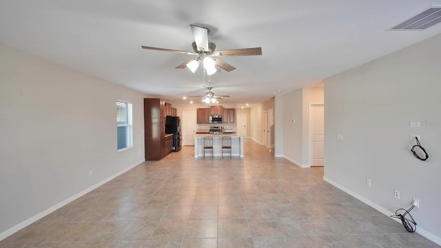 unfurnished living room featuring ceiling fan and light tile patterned floors