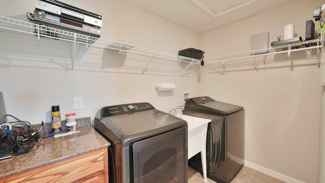 laundry room with light tile patterned floors and washer and clothes dryer