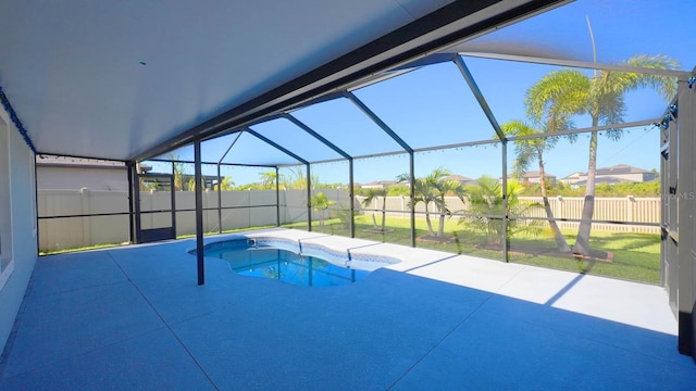 view of swimming pool featuring glass enclosure and a patio