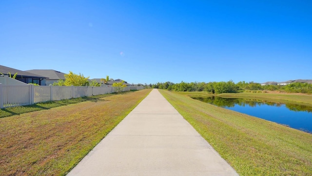 view of property's community featuring a yard and a water view