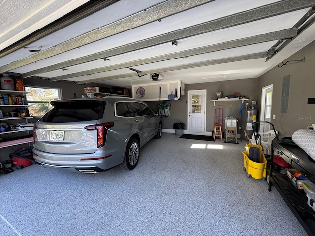 garage with electric panel, a garage door opener, and electric water heater