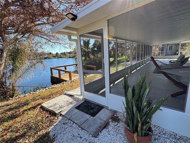 exterior space featuring a sunroom and a water view